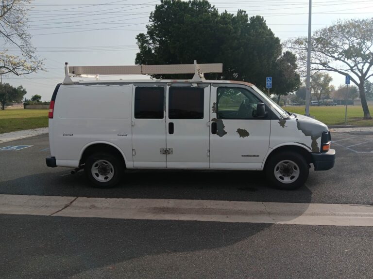 A used white Chevrolet Express cargo van with ladder rack purchased for cash by GoCarBuyer in Los Angeles, California