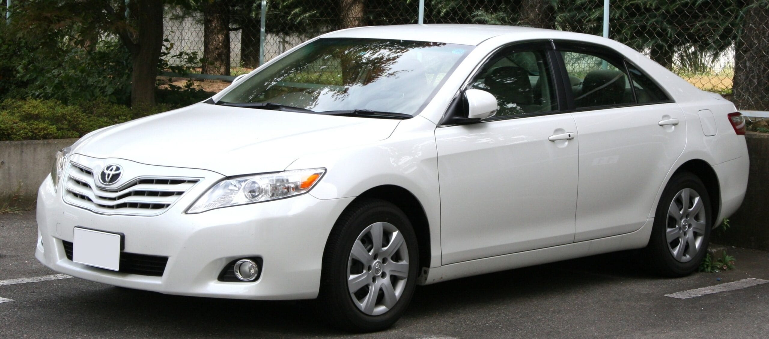 Used White Toyota Camry Sedan-car-buyer White Toyota Camry sedan parked in a parking lot
