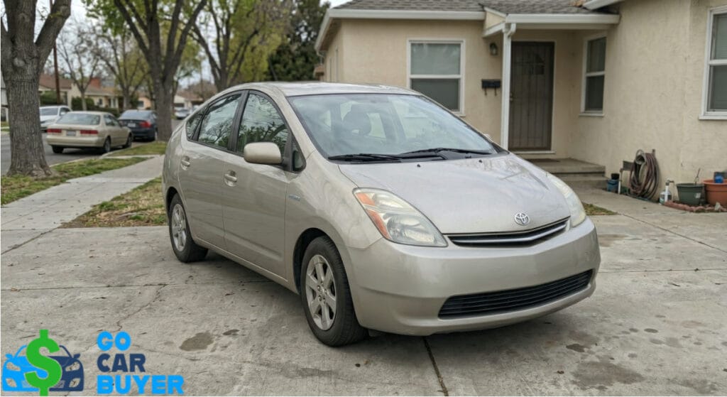 A clean silver 2nd generation Toyota Prius parked in a residential driveway in Orange County. GoCarBuyer pays cash for used and high-mileage hybrid vehicles.