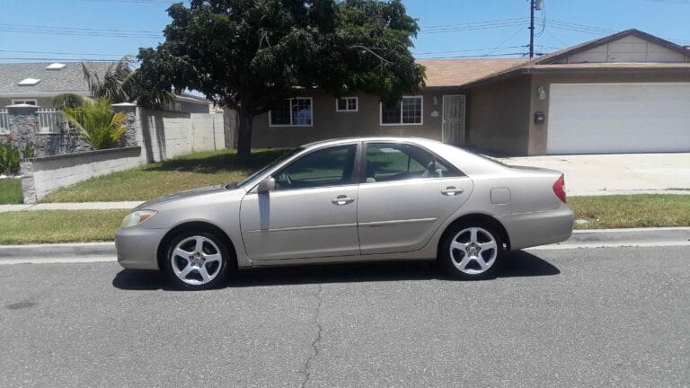 A gold 5th Generation Toyota Camry parked on a residential street in Orange County. GoCarBuyer pays cash for used Camrys in any condition across SoCal.