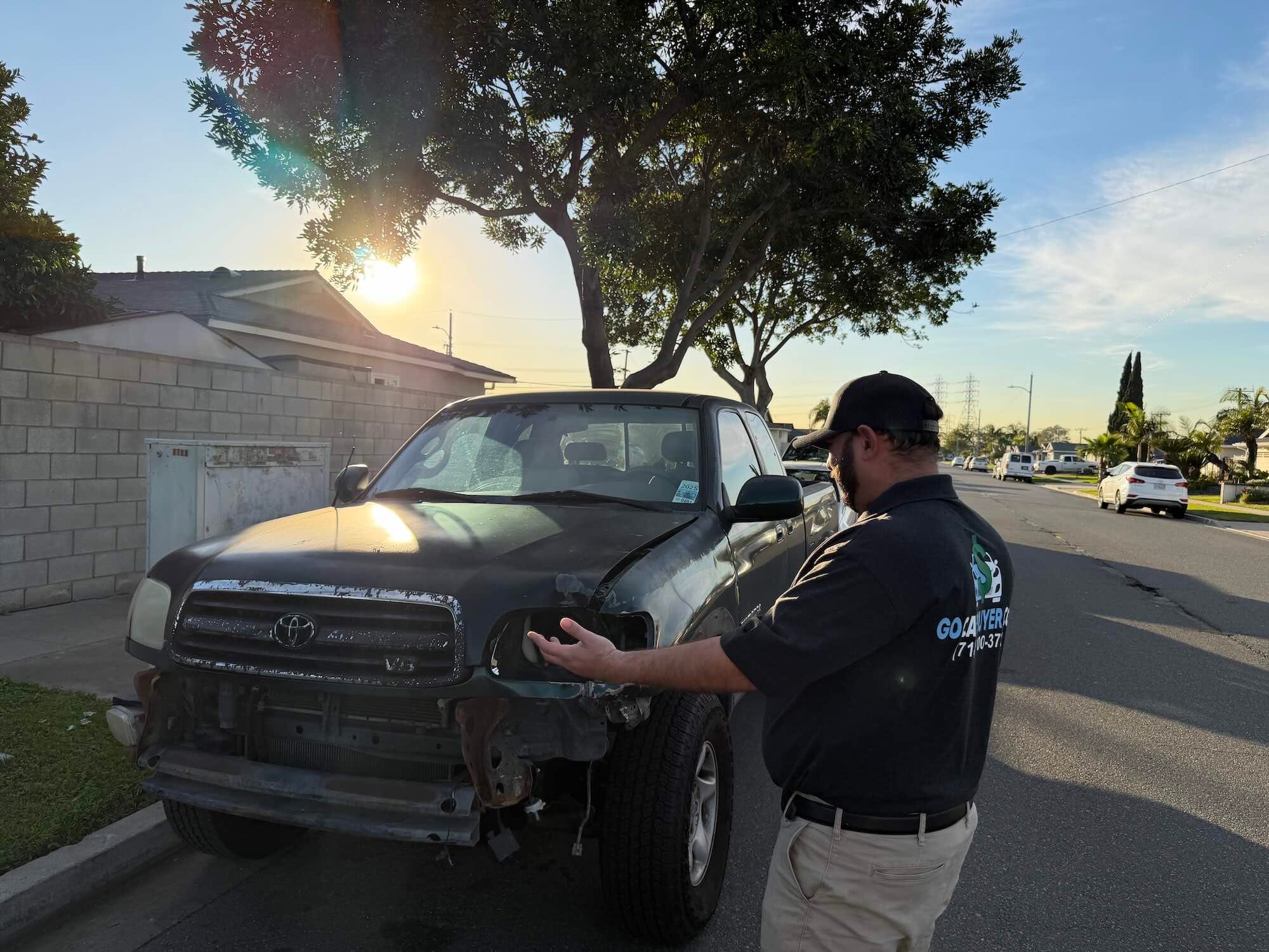 Accident damage on a dark green Toyota Tundra truck, which is missing its front bumper and headlight assembly. This is an example of a vehicle GoCarBuyer will buy for cash.
